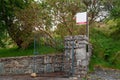 For sale blank sign at a gate of a property on an old stone fence. Real estate business. Mature property on the market to purchase