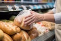 sale of bread in a supermarket, hand takes a loaf of bread generative ai