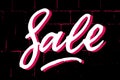 Sale brush textured hand written lettering sign. White shadowed letters on black and neon pink brick wall background