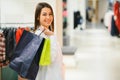 Sale, clothes , shopping, fashion and people concept - happy young woman choosing between two shirts in mall or clothing store Royalty Free Stock Photo