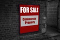 For sale with commercial property written on a sign attached to a wall