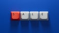 sale.Computer keyboard keys spelling.Flat lay view from above on blue background Royalty Free Stock Photo