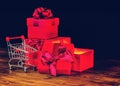 sale concert, presents, holiday greeting card with festive opened boxes with bow and shopping cart on wooden background, close up