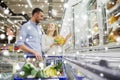 Couple with shopping cart buying food at grocery Royalty Free Stock Photo