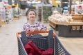 sale, consumerism and people concept - happy little girl with food in shopping cart at grocery store Royalty Free Stock Photo