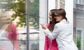 Sale, consumerism and people concept - happy surprised young women pointing with finger at shop window outdoors Royalty Free Stock Photo