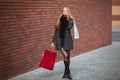 Sale, consumerism and people concept - happy young beautiful women holding shopping bags, walking away from shop. Royalty Free Stock Photo