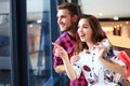 Sale, consumerism and people concept - happy young couple with shopping bags walking in mall. Royalty Free Stock Photo