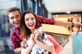 Sale, consumerism and people concept - happy young couple with shopping bags walking in mall. Royalty Free Stock Photo