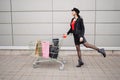 Sale, consumerism and people concept - happy young woman in jump with shopping bags along city street Royalty Free Stock Photo