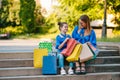 Sale, consumerism and people concept - happy young women her dauther with shopping bags walking city street Royalty Free Stock Photo