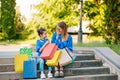 Sale, consumerism and people concept - happy young women her dauther with shopping bags walking city street Royalty Free Stock Photo