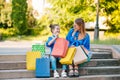 Sale, consumerism and people concept - happy young women her dauther with shopping bags walking city street Royalty Free Stock Photo