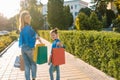 sale, consumerism and people concept - happy young women her dauther with shopping bags walking city street Royalty Free Stock Photo