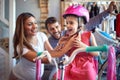 Sale, consumerism and people concept - woman choosing new bicycle and helmet for little girl in bike shop Royalty Free Stock Photo