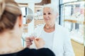 Sale, consumerism, shopping and people concept. Happy grey haired elderly woman buying some jewelry. Blond woman owner Royalty Free Stock Photo