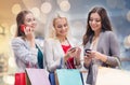 Happy women with smartphones and shopping bags