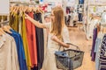 Sale, fashion, consumerism and people concept - happy young woman with shopping bags choosing clothes in mall or clothing store Royalty Free Stock Photo