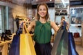 Happy young woman with shopping bags at shoestore Royalty Free Stock Photo