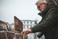 Sale at the flea market. Interested mature man chooses antiques at a street shop. Tourist buys souvenirs Royalty Free Stock Photo