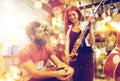 Couple of musicians with guitar at music store