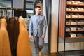 sale, shopping, fashion, style and people concept - elegant young man in suit in mall or clothing store Royalty Free Stock Photo