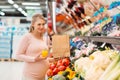 Pregnant woman buying vegetables at grocery store Royalty Free Stock Photo