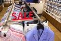 Sale sign in the department of men`s shirts and jackets in the store. Colorful clothes on hangers in a retail shop. Season sale, Royalty Free Stock Photo