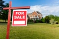 For sale sign in front of large USA home Royalty Free Stock Photo