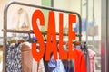 A Sale sign on glass wall outside a clothing store or apparel shop Royalty Free Stock Photo