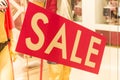 Sale sign stands on a rack with things in the store Royalty Free Stock Photo