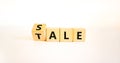 Sale or tale symbol. Turned wooden cubes and changed the concept word Tale to Sale. Beautiful white table white background, copy