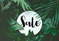 Sale text with real leaves tropical jungle background.