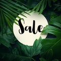 Sale text with real leaves tropical jungle background.