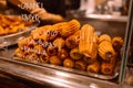 Sale of traditional sweets churros with condensed milk filling inside. Fair stall with typical spanish donuts Royalty Free Stock Photo
