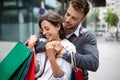 Sale, travel love consumerism and people concept. Happy couple with shopping bags in the city