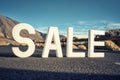 `Sale` white letters on the asphalt road near Teide volcano, blue sky, sunny light