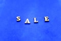 Sale wooden letters on blue background