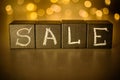 Sale word chalk written on black cubes on blurred bokeh background Royalty Free Stock Photo