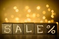 Sale % word chalk written on black cubes on blurred bokeh background Royalty Free Stock Photo