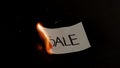 Sale word written on white paper burns. Fire with smoke and ashes on black background Royalty Free Stock Photo