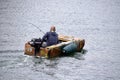 A man in a boat fishing close to Derby Wharf. Salem, MA, USA. September 29, 2016.