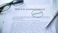 Sales agreement approved, seal stamped on official document, business contract