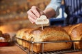 Sales Assistant In Bakery Putting Gluten Free Label Into Freshly Baked Baked Sourdough Loaves Of Bread