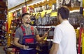 Sales assistant at hardware store helping customer choose tools for home repairs Royalty Free Stock Photo