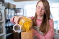 Sales Assistant In Sustainable Plastic Free Grocery Store Weighing Pasta Into Paper Bag