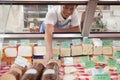 Sales Clerk reaching in to get cheese at Deli counter Royalty Free Stock Photo