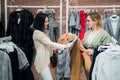 Sales consultant helping chooses clothes for the customer in the store. Shopping with stylist concept. Female shop Royalty Free Stock Photo