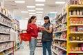 The sales consultant looks at the product, listening to the buyer`s complaint. Two young Caucasian women. Concept of shopping,
