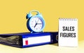 Sales Figures - text on a notebook next to the folder and the clock Royalty Free Stock Photo